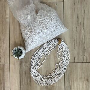 Bag full of white Mardi Gras white bead necklaces.